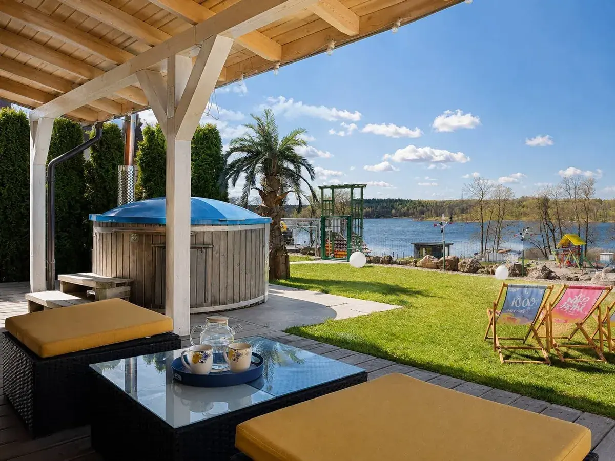 Überdachte Terrasse mit Möbeln und Seeblick